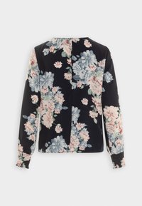 Top a maniche lunghe floreale con sfondo nero, con fiori rosa e blu, polsini arricciati e un'apertura sul retro per dettagli.
