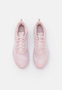 Zapatillas deportivas de color rosa claro con parte superior de malla texturizada, cuello acolchado y cordones blancos. Cuenta con un acento del logo y una suela de goma resistente.