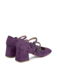 Des chaussures en daim violettes à talon bloc et bout pointu, présentant deux sangles ornées et des accents de gemmes décoratives sur chaque sangle.