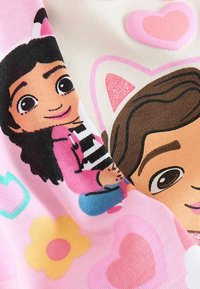 Bunte Stoffe mit Cartoonfiguren mit schwarzen Haaren in einem pink-weißen Design, akzentuiert mit Herzen und Blumen in lebhaften Farben.