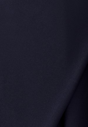 Glad donker marineblauw stof met een lichte diagonale vouw die subtiele schaduwen en textuur creëert.