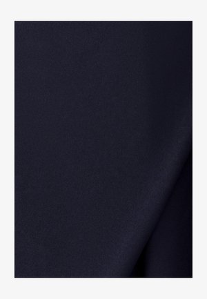 Glad donker marineblauw stof met een lichte diagonale vouw die subtiele schaduwen en textuur creëert.