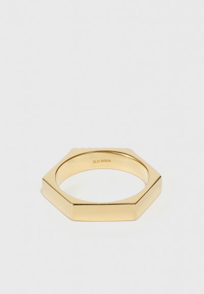 Sechseckiger Ring in poliertem Goldton. Glatte Oberfläche mit flachen Kanten und subtiler Gravur innen. Minimalistisches Design mit geometrischer Form.
