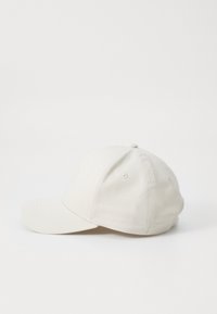 Hvid bomulds baseball cap med en buet skygge, seks-panel design og broderede øjelet. Glat tekstur, ingen synlige mønstre eller logoer.