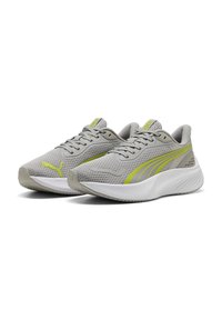 Zapatillas deportivas ligeras en malla gris con acentos amarillos, que cuentan con una suela blanca acolchada y cordones, diseñadas para la comodidad y el rendimiento.