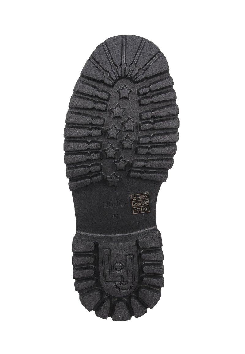 Semelle de chaussure en caoutchouc noir dotée d'un motif texturé avec des formes d'étoiles, des stries et un logo en relief sur la zone du talon.