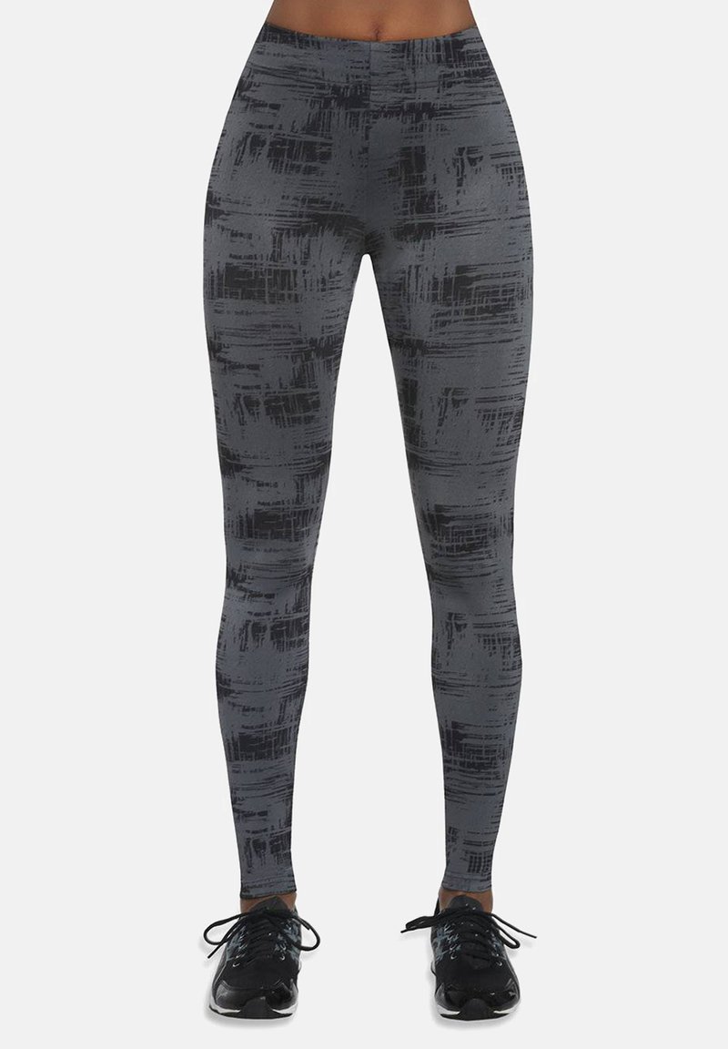 Szare legginsy z fakturowanym, abstrakcyjnym czarnym wzorem, wysokim stanem i elastycznym materiałem, w zestawieniu z czarnymi butami sportowymi.