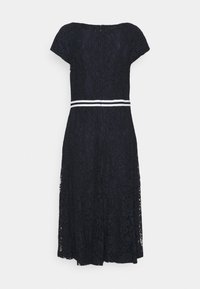 Tmavě modré krajkové midi šaty s krátkými rukávy a bílými dvojitými pruhy kolem pasu, zobrazené zezadu na jednobarevném pozadí.