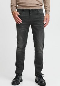 Hallid hall denim püksid, kitsas lõige, viie tasku disain ja kerge nädalavahetuse fade. Kombineeritud mustade nahkkingade ja beeži sviitriga.