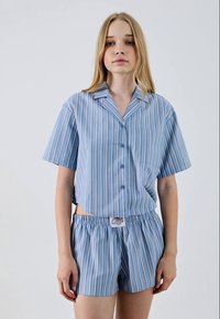 Blue striped short-sleeve shirt with a button placket and pocket, paired with matching striped shorts featuring an elastic waistband.