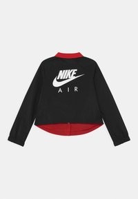 Černá bunda s červeným límcem a manžetami, na zadní straně s bílým potiskem "NIKE AIR". Strukturovaná tkanina, zkrácený střih s knoflíkovým zapínáním.