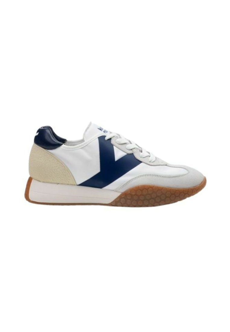 Sneaker bianca con dettagli in blu navy e beige, dotata di una suola in gomma testurizzata con un motivo a nido d'ape e chiusura con lacci.