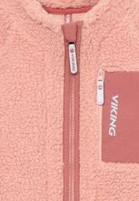 Rózsaszín fleece dzseki puha, textúrált felülettel, elülső cipzárral, mellzsebbel és világoskék "VIKING" márkajelzéssel.