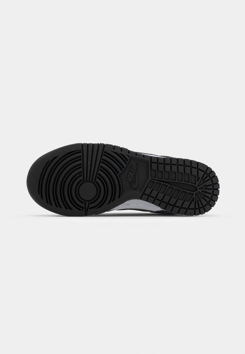 Sole di sneaker Nike, in gomma nera con texture a motivi circolari e lineari. Presenta un logo e un design del battistrada per la trazione.