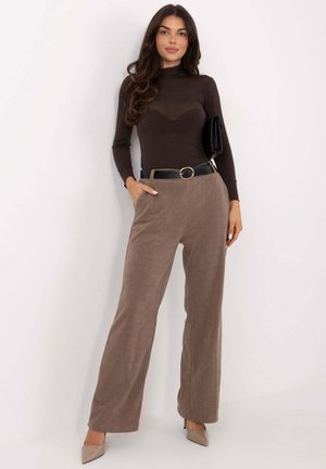 Brązowe body z długim rękawem w połączeniu z beżowymi szerokimi spodniami sztruksowymi, uzupełnione czarnym paskiem z okrągłą klamrą oraz czarną kopertówką.