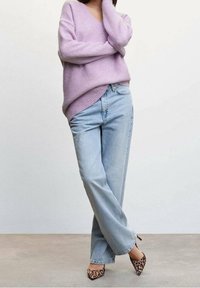 Pull oversize lilas avec col en V, associé à un jean droit délavé clair et des talons pointus imprimés léopard marron.