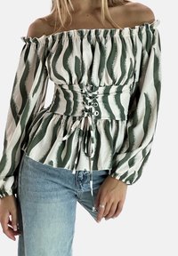 Axelbandslös blus i vitt och grönt randigt mönster, med insvängd midja och snörningsdetalj samt flödande långa ärmar.