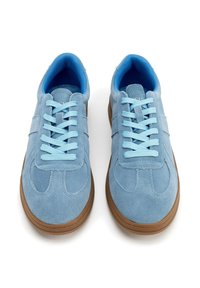 Helleblaue Wildledersneaker mit hellblauen Schnürsenkeln, runder Zehenform und brauner Gummisohle. Weicher Stoff und schlichtes Design mit minimalen Akzenten.