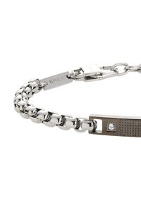 Pulsera de cadena de plata con eslabones pulidos y texturizados, que cuenta con un broche rectangular con un acento de diamante y un detalle de marca grabado.