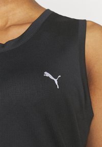 Must mustriga jooksu tipp ilma varrukateta, ribakujundusega, V-kaelusega, millel on vasakul rinnal väike valge Puma logo.