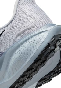 Jasnoszare buty do biegania z teksturowaną siateczką, logo Nike React oraz gumową podeszwą z wzorami dla lepszej przyczepności.