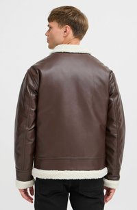 Chaqueta de cuero marrón con cuello y puños de piel de oveja blanca, con un diseño corto y textura suave. Vista trasera mostrada.