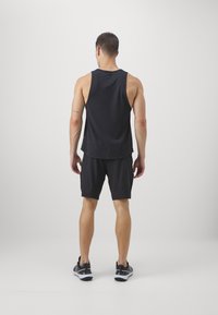 Svart atletisk linne och shorts, med en avslappnad passform och lättviktig tyg, med en slät textur och minimalistisk design.