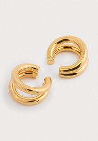 Złote kolczyki hoop z gładką, błyszczącą powierzchnią, ozdobione skręconym wzorem i otwartą formą.