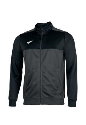 Chaqueta deportiva negra y gris oscuro con cremallera completa, cuello alto, mangas largas, bolsillos laterales y un pequeño logo blanco en la parte superior izquierda del pecho.