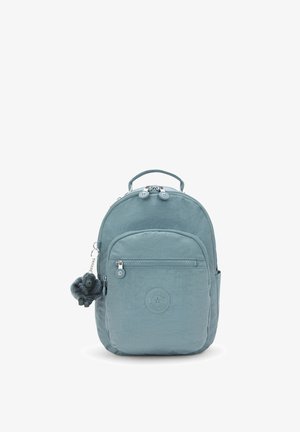 Small light blue backpack with front zip pocket, top handle, and plush monkey keychain hanging on side zipper.
