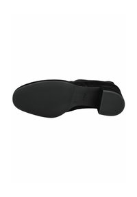 Scarpa in suede nera con suola in gomma liscia, punta rotonda e tacco quadrato basso. La parte inferiore presenta un motivo di grip testurizzato e il logo del marchio.