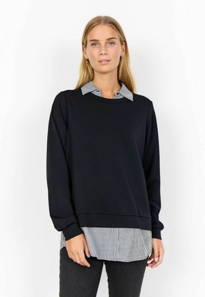 Sweat-shirt noir superposé sur une chemise à col noir et blanc à rayures. Il a des manches longues et une coupe décontractée. Texture lisse, design décontracté.