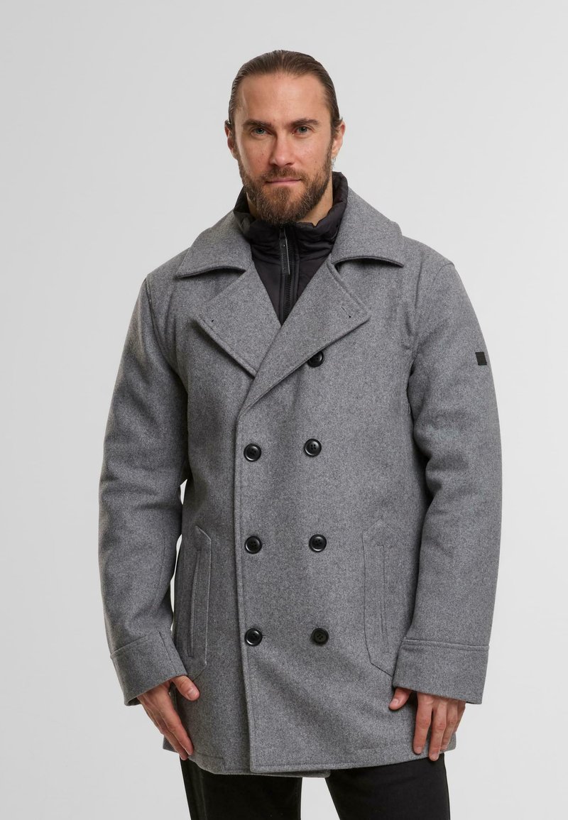 Grijze wollen peacoat met een dubbelzijdig ontwerp, grote zwarte knopen en zijzakken over een zwarte, met rits gesloten binnenlaag.