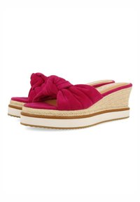 Sandalias de cuña de ante fucsia con diseño superior anudado, plantilla envuelta en yute y suela de goma. Acentuadas con una franja blanca lisa.