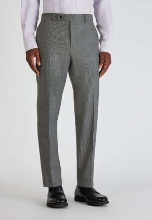 Grijze geblokte herenbroek met een textuurafwerking, voorzien van een vlakke voorkant, zijzakken en een enkele knoopsluiting. Gecombineerd met zwarte schoenen.