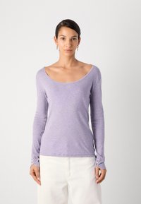 Langermet lilla topp med bred utringning og knappe mansjetter, laget av lettvektig stoff med en glatt tekstur.