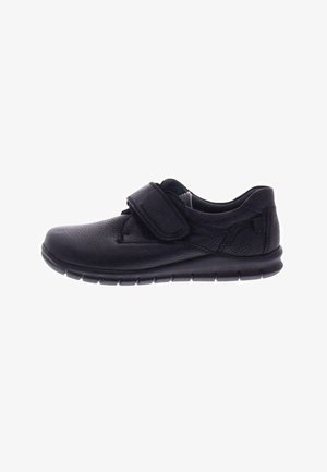 Black leather shoe with a textured surface, adjustable Velcro strap, and a flexible rubber sole designed for comfort and ease of use.