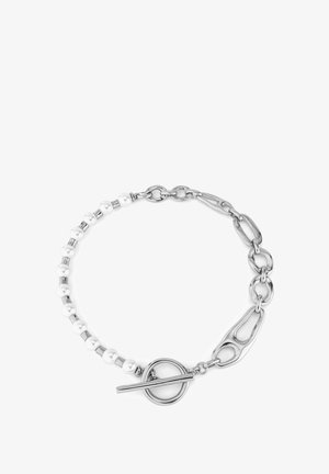 Pulsera de cadena de plata con cuentas blancas, eslabones ovalados y un cierre de palanca. Textura suave con un diseño alternando cuentas y cadena.