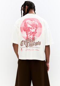 Short-sleeve, cream-colored T-shirt featuring a pink graphic design of a classical bust and text reading "Changing Constants" on the back.