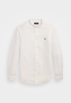 Weißes Leinenhemd mit langen Ärmeln, Stehkragen und gelben Knöpfen. Verfügt über ein kleines navyfarbenes Logo auf der linken Brust.