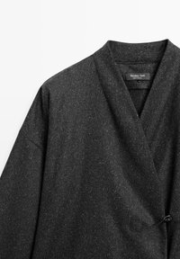 Veste portefeuille en mélange de laine gris foncé moucheté avec large col et fermeture à nouer sur le côté, étiquetée Massimo Dutti, fabriquée au Portugal.