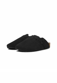 Des chaussures noires en daim à enfiler, avec un bout pointu, des accents de sangle et une semelle en liège texturée pour une meilleure adhérence.