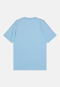 Camiseta de manga corta azul claro con cuello redondo y acentos en negro contrastantes en los hombros; tejido suave y sin textura.