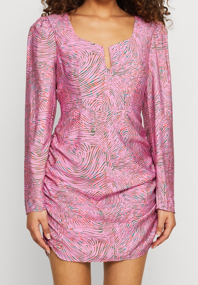 Vaaleanpunainen pitkähihaiset mekko, jossa on syvä V-pääntie ja kieppumalli eri väreissä. Kankaassa on hieman kiiltoa ja joustavaa rypytystä vyötäröllä.