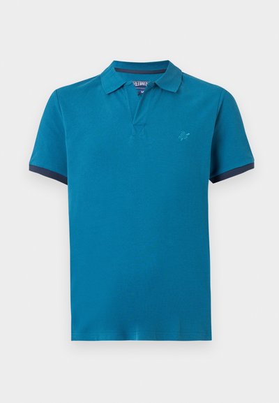 Τυρκουάζ κοντομάνικη πόλο μπλούζα με γιακά, λεπτομέρεια σε ναυτικό μπλε στα άκρα των μανικιών και μικρό κεντημένο λογότυπο στο αριστερό στήθος.