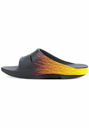 Black slide sandal with a textured surface, featuring a bold yellow and red diagonal stripe pattern along the side. Designed for comfort.