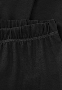 Zwarte elastische tailleband, glad gebreid materiaal, met een geplooide bovenrand, met een zachte textuur en flexibele pasvorm voor comfort.