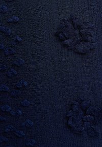 Navy fabric with a textured finish, featuring raised floral patterns and small scattered embellishments. Soft, woven texture.