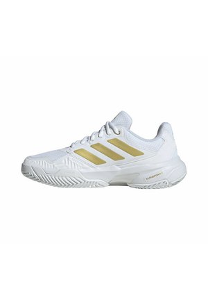 Zapatilla deportiva Adidas blanca de bajo perfil con rayas doradas, parte superior de malla, suela acolchada y suela exterior con dibujo diseñada para comodidad y durabilidad.
