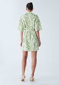 Kortærmet kjole i letvægtsstof med et grønt og hvidt zebramønster, med taljeret talje og lige kant.